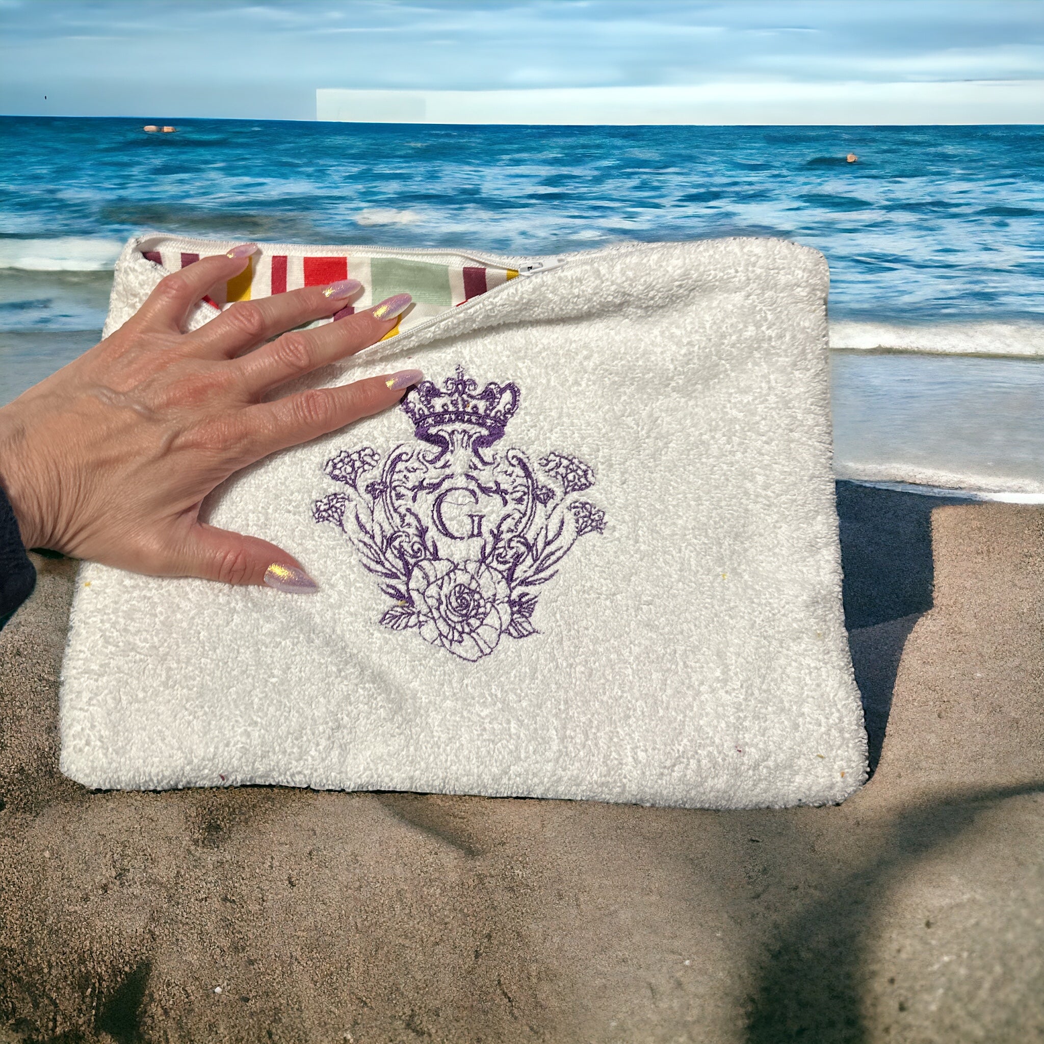 Pochette en éponge Bonnie Blanche intérieur en cretonne enduite rayé et son logo Parme