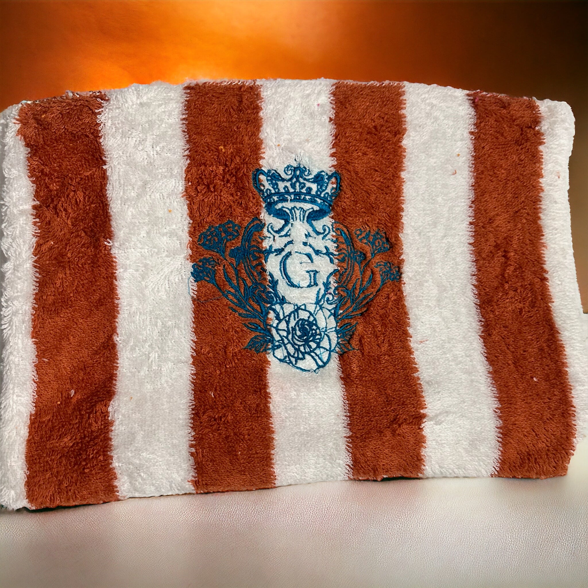 Pochette XL en éponge rayé terracotta(blanc et orange) intérieur en cretonne et son logo Bleu