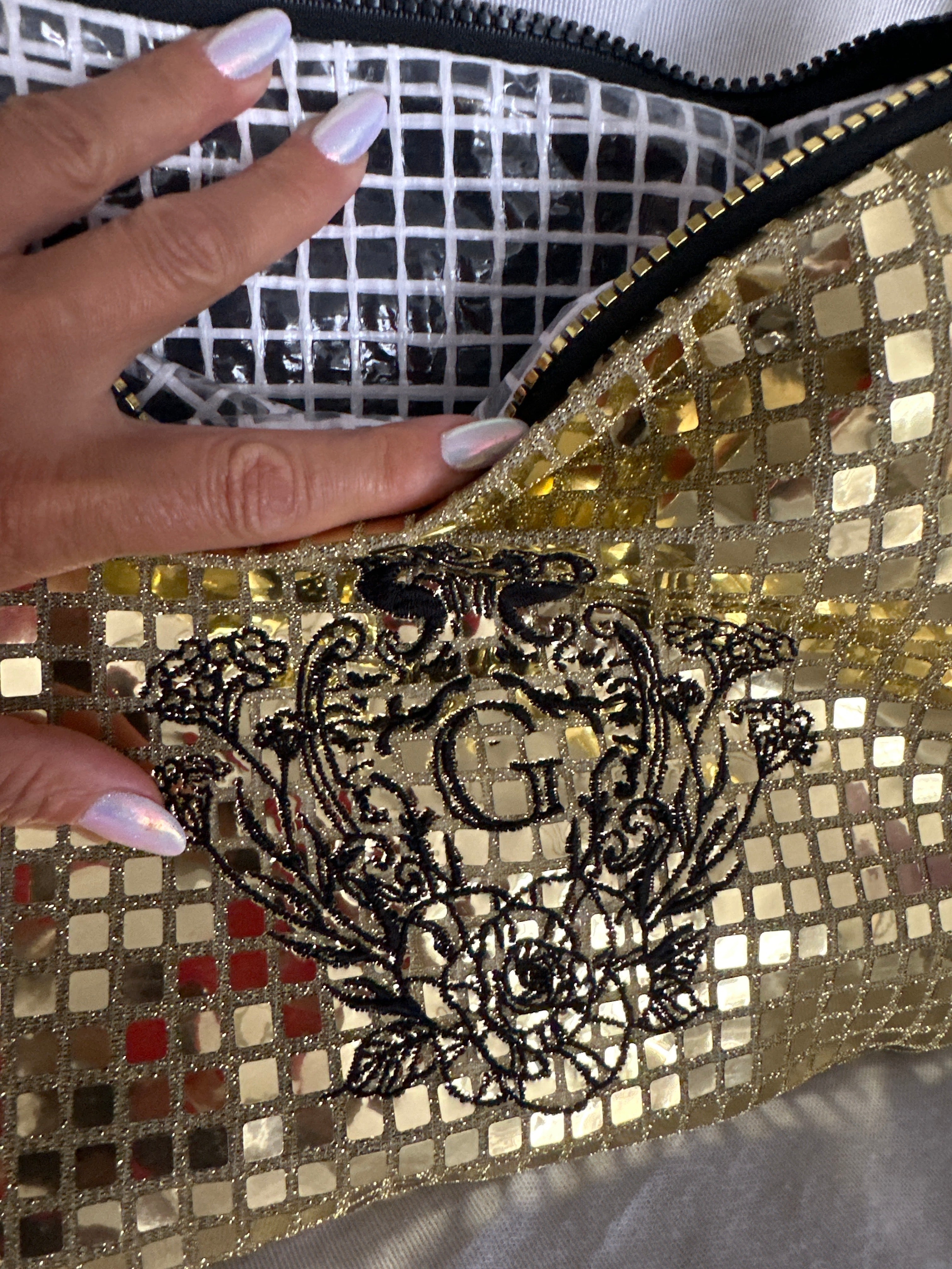 Pochette XL paillettes carrées Dorée sa doublure transparente plastifiée et son logo Noir