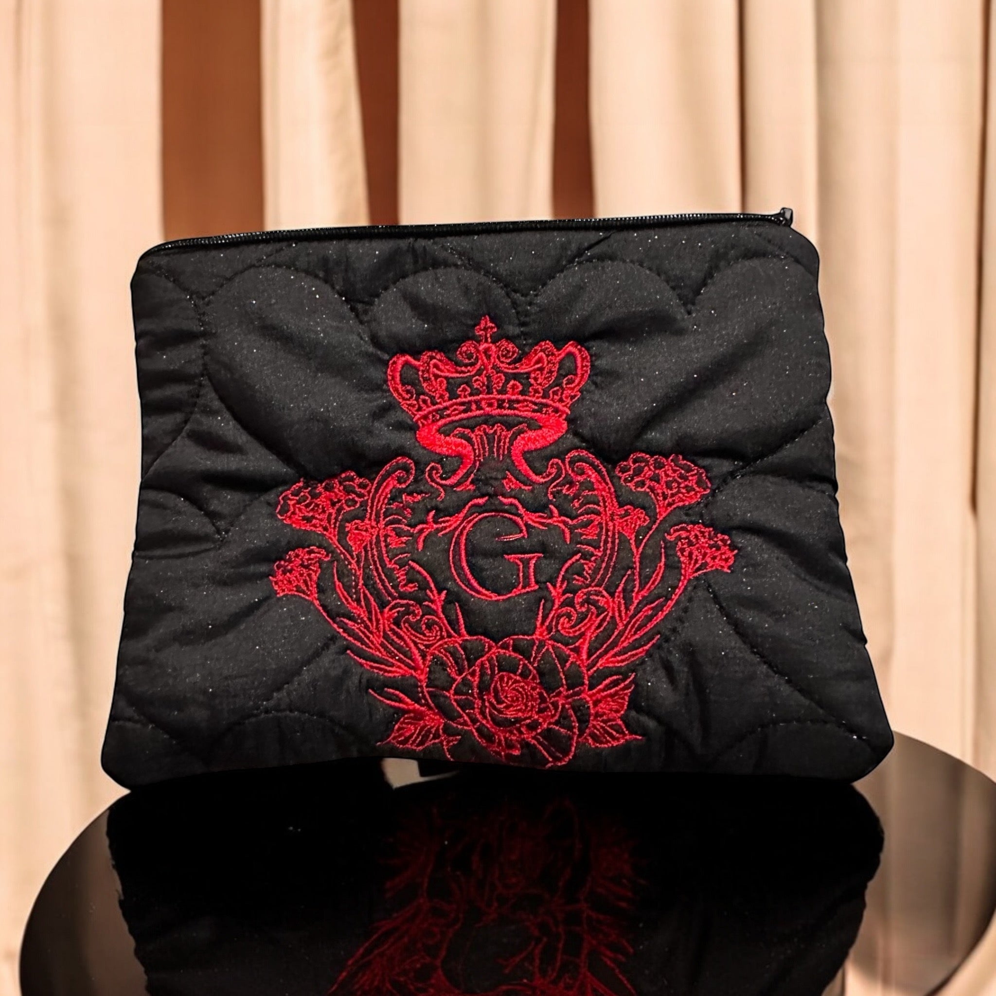 Pochette noir en tissu matelassé cœurs paillettes noir ouaté intérieur en flanelle rouge et vert et son logo brodé Rouge