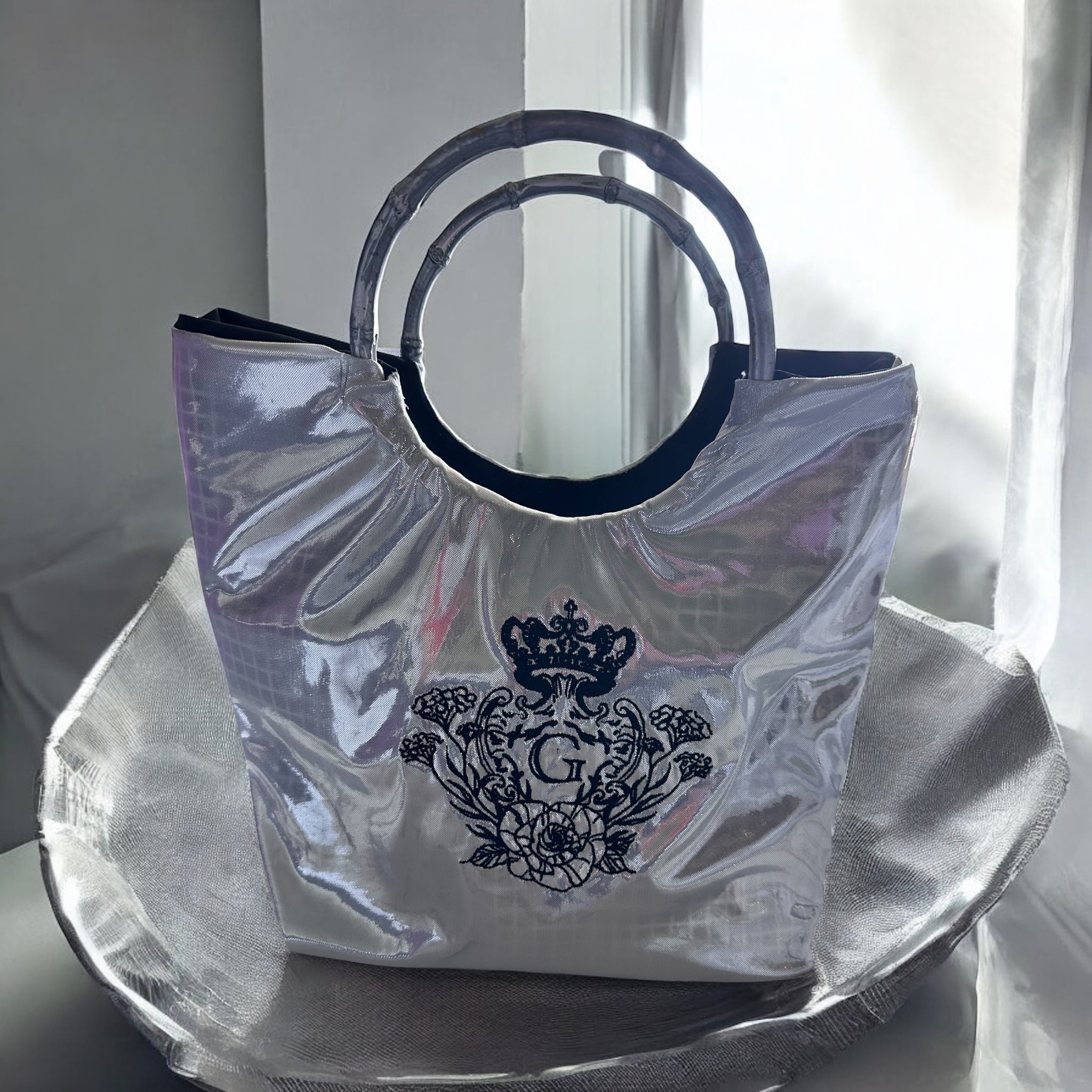 Sac moyen laser uni blanc et argent sa doublure en cretonne enduite noir et son logo noir