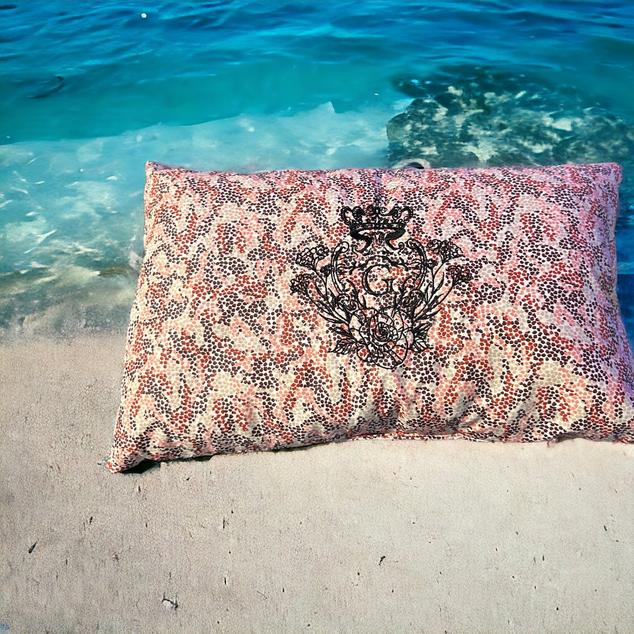 Coussin de plage en cretonne enduite thème mosaïque de couleur rose, Bordeaux et beige sur fond écru et son logo Noir